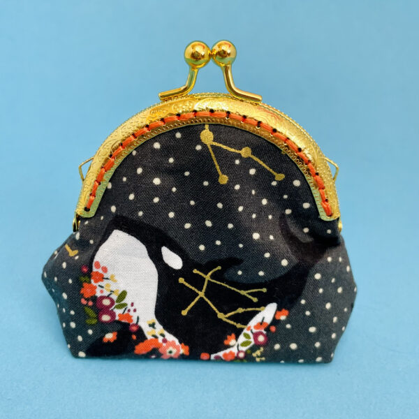 Coin purse with gold clasp and whale fabric.