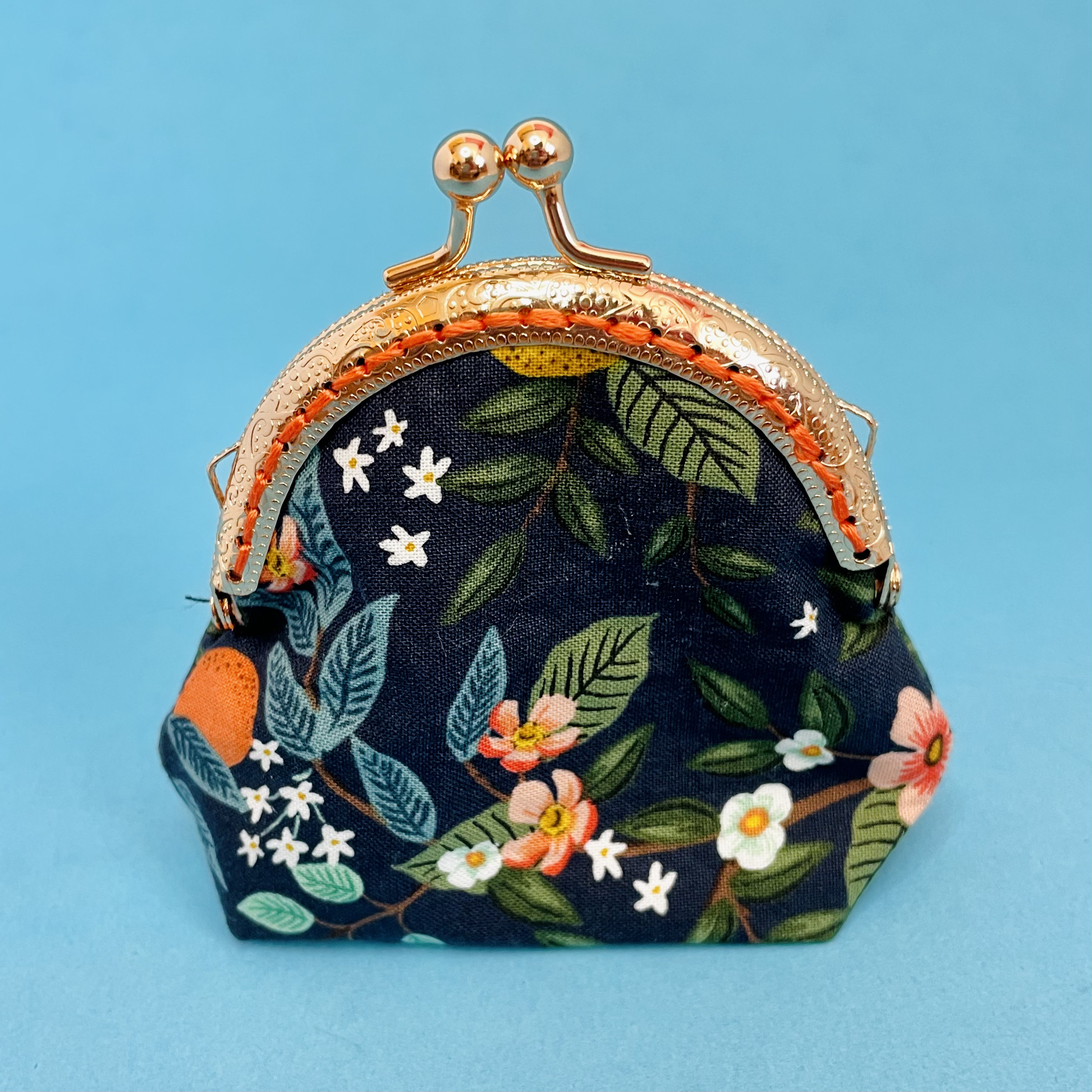 Coin Purse with dark green with a floral print. Lemons, oranges and light green blossoms.